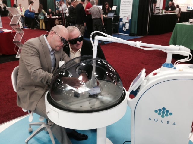 An intrigued dentist watches as Dr. David Fantarella cuts an extracted tooth with Solea.